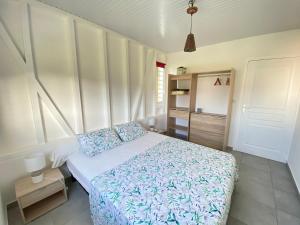 a bedroom with a bed with blue and white sheets at Le Royal Horizon in Deshaies