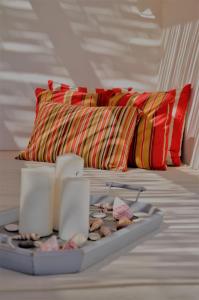 a bed with two pillows and a tray of shells at Pambelos Lodge in Koufonisia