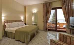 En eller flere senge i et værelse på Hotel Villa Poseidon & Events