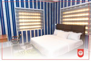 een slaapkamer met een bed en een blauwe en witte streepmuur bij Covenant Hotel in Accra