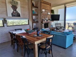 comedor y sala de estar con mesa y sillas en Casa Punta lobos - Pichilemu. A pasos de la playa condominio privado, en Pichilemu
