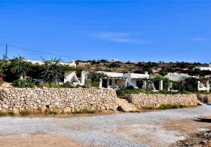 a stone wall in front of a house at Pambelos Lodge in Koufonisia