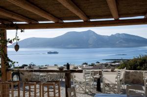 - une table avec des chaises et une vue sur l'océan dans l'établissement Pambelos Lodge, à Koufonisia