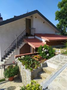 a house with a staircase and flowers in front of it at AGRITURISMO TERRE VERAE in Neirone