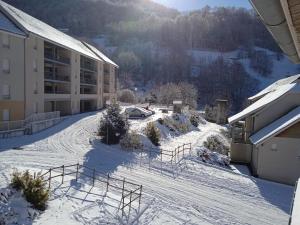 una entrada cubierta de nieve de un edificio con un coche aparcado en Studio Ceriséma Pyrénées Zénith, en Luz-Saint-Sauveur