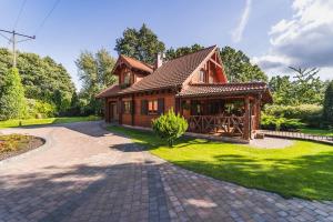 una pequeña casa de madera con entrada de ladrillo en Woodhouse en Łubowo