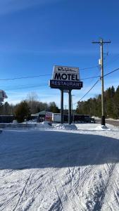 Un cartel de motel en medio de una carretera cubierta de nieve en Rolphton Motel and Restaurant, en Moor Lake Station