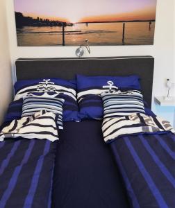 ボートマン・ルートヴィヒスハーフェンにあるFeWo Segelwindのベッド(青と白のストライプの枕付)