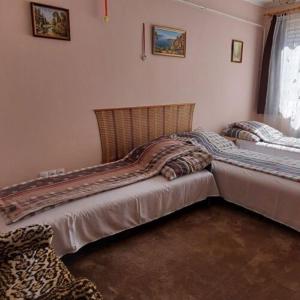 dwa łóżka siedzące obok siebie w sypialni w obiekcie Bundik Vendégház w mieście Berettyóújfalu