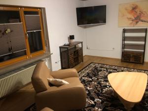 ein Wohnzimmer mit einem Stuhl und einem TV in der Unterkunft Ferienwohnung Tom in Schnaittenbach