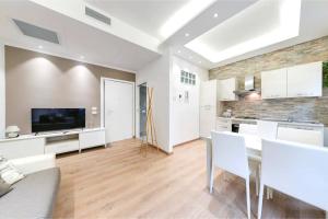 een keuken en een woonkamer met witte meubels en een flatscreen-tv bij Ariston - Ciclabile Appartamento in CENTRO a Sanremo in Sanremo