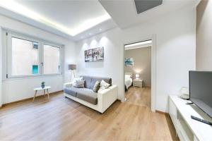 Sala de estar blanca con sofá y TV en Ariston - Ciclabile Appartamento in CENTRO a Sanremo en Sanremo