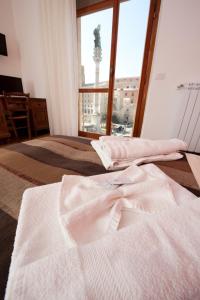 een slaapkamer met 2 bedden en een groot raam bij Leccesalento Bed And Breakfast in Lecce