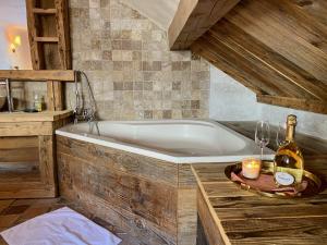 a bathroom with a tub and a bottle of champagne at Charming chalet 100m2, Heart of the 3 vallées, Meribel, Les Allues in Les Allues