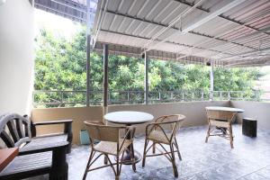 un patio con mesa, sillas y ventanas en OYO 507 Aikka Hotel en Butterworth