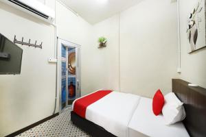 Un pat sau paturi într-o cameră la OYO 507 Aikka Hotel