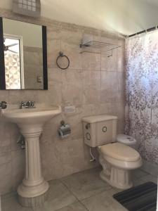 a bathroom with a sink and a toilet and a mirror at Hotel Posada Mercy in Río Lagartos