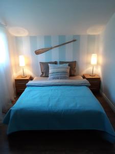 a bedroom with a blue bed with two lamps at Ostrowo domek in Ostrowo