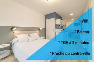 1 dormitorio con 1 cama blanca y cocina blanca en apparthotel-gare-chambery, en Chambéry