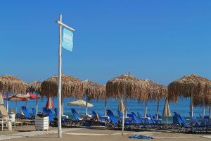 eine Gruppe von Stühlen und Sonnenschirmen am Strand in der Unterkunft Sonio Beach - Que Bella Collection in Platanias