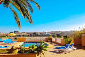 a resort with a pool and chairs and a palm tree at Finca Palacios - comfortable holiday accommodation in Benissa in Benissa