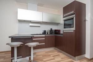 een keuken met een aanrecht en twee krukken erin bij City Centre Sky View Apartment on 27th Floor in Tallinn +2 foto's