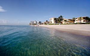 a view of the beach with buildings in the background at Windjammer Resort and Beach Club in Fort Lauderdale
