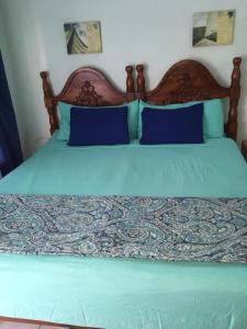 ein Bett mit zwei blauen Kissen darüber in der Unterkunft Panoramic View@Sky Castles, Columbus Heights in Ocho Rios