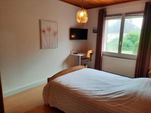 um quarto com uma cama e uma janela em Gite Les Quat'vents em Boulleret