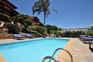 ein großer Pool mit Stühlen und ein Resort in der Unterkunft Aguabúzios Hotel in Búzios