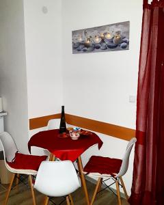 una mesa y sillas con un mantel rojo. en Snowman Studio Apartment Jahorina en Jahorina