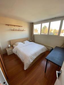 - une chambre avec un grand lit blanc et une table dans l'établissement Chambre calme (Mercure) - proche Paris et TGV, à Massy