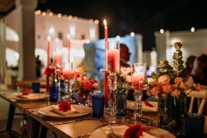 Una mesa larga con velas y flores. en Masseria D'Erchia, en Monopoli