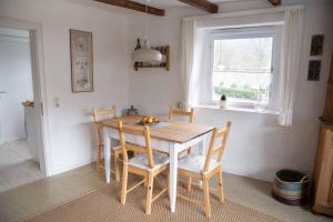 a kitchen with a wooden table with chairs and a window at Bergische Ferienwohnung in Engelskirchen