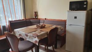 a table with chairs and a refrigerator in a room at Ruttkai Vendégház in Székesfehérvár
