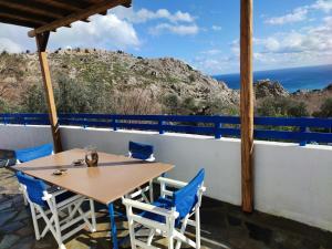 Una mesa y sillas en un balcón con vista al mar. en Ioli's Apartments, en Archangelos