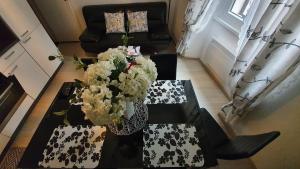 a living room with a table with flowers on it at Apartments Paris in Umag