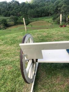 a white cart sitting on top of a field at Sítio com Piscina e Vista a 12km de Treze Tílias in Ibicaré