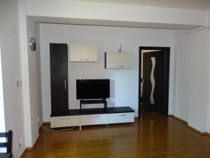a living room with a flat screen tv on a cabinet at Alpin Residence in Sinaia