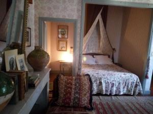 1 dormitorio con cama con dosel y silla en Domaine d'Audabiac, en Lussan