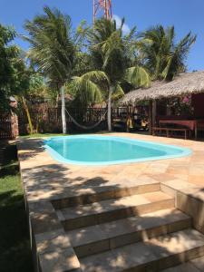- une piscine dans une cour avec des palmiers dans l'établissement Casa Bouganville apartamento 4, à Jericoacoara