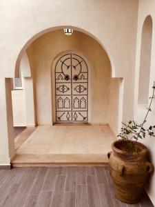 a room with a door with a plant in front of it at Dar ABDELKRIM in Al Ḩaddādah