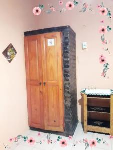 uma porta de madeira num quarto com flores na parede em Residencial Azaleas Place Guest House em Puerto Iguazú