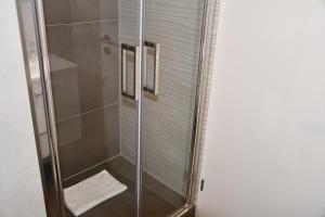 a shower with a glass door with a white towel at Vicky´s Ferienwohnung Am Nordertor in Flensburg