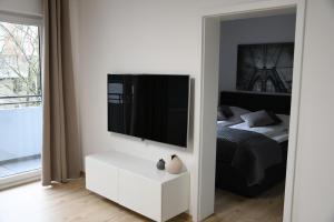 a bedroom with a tv on a wall and a bed at Vicky´s Ferienwohnung Am Nordertor in Flensburg