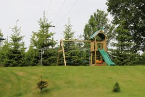a playground in a field with a slide at Ferienwohnung am Erlermuhlenbach in Voigtsdorf