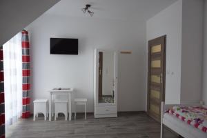 una camera con letto, tavolo e specchio di Noclegi u Eweliny a Krajno Pierwsze