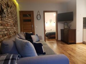 a living room with a blue couch and a brick wall at Apartamenty 33 in Zakopane