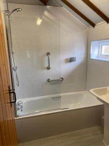 a shower with a glass door in a bathroom at Bank Farm Cottages in Nantwich +27 photos