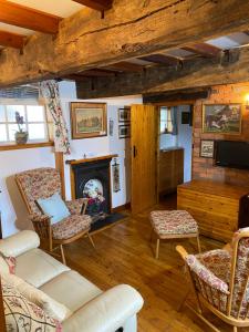 a living room with chairs and a fireplace at Bank Farm Cottages in Nantwich